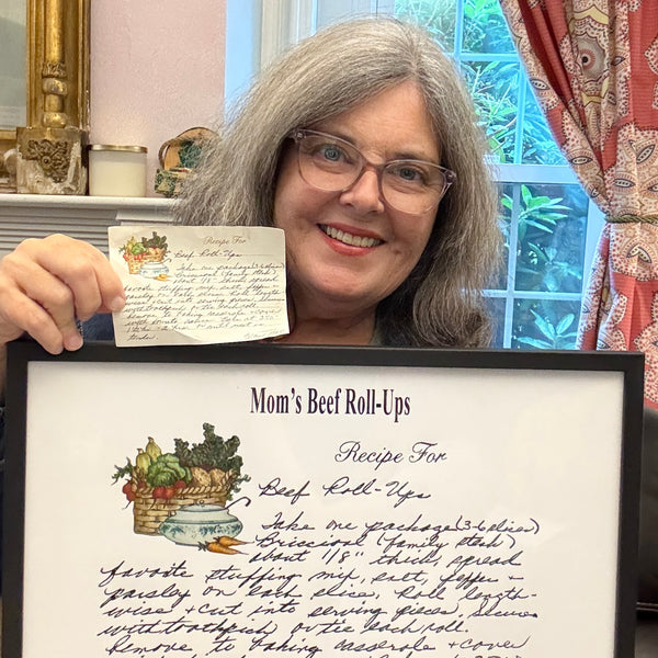 Woman holding a recipe card and a frame with the cleaned up recipe design. The Printed Gift