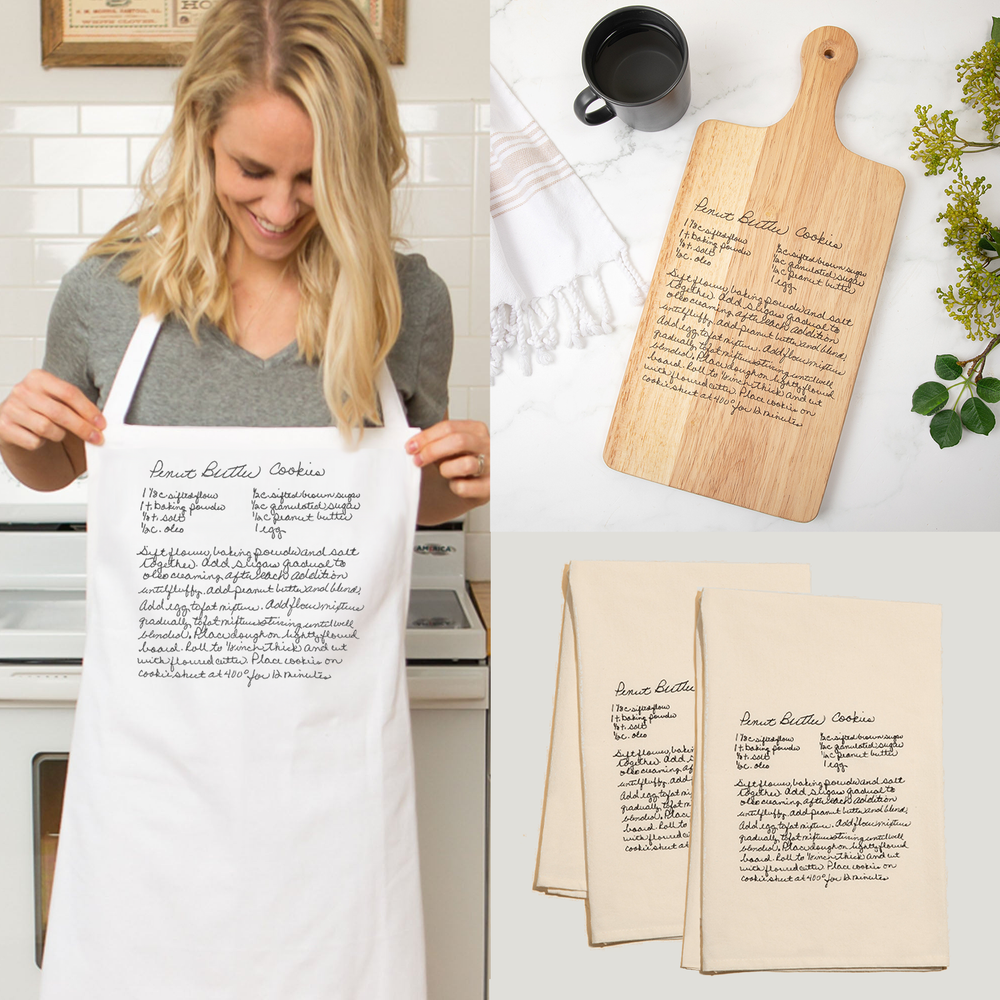Woman wearing a personalized apron with handwritten recipes, next to a wooden cutting board and kitchen towels with similar text.